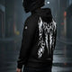 Motorcyclist wearing the LUMA Rider hoodie on a rainy city street, back graphic visible