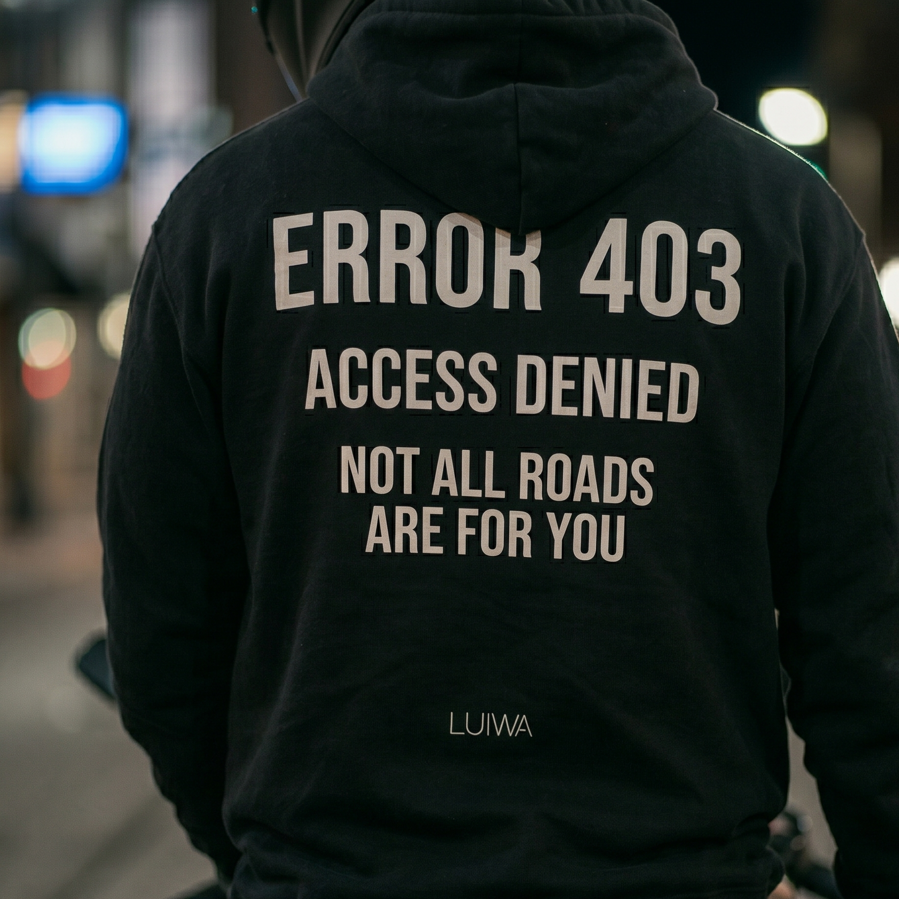 Black hoodie with 'ERROR 403 ACCESS DENIED NOT ALL ROADS ARE FOR YOU' text on the back, worn by a person in an urban setting.