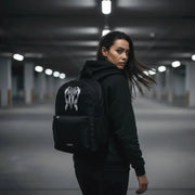 Woman glancing back while wearing the LUMA Tribal Ram backpack in an urban parking garage