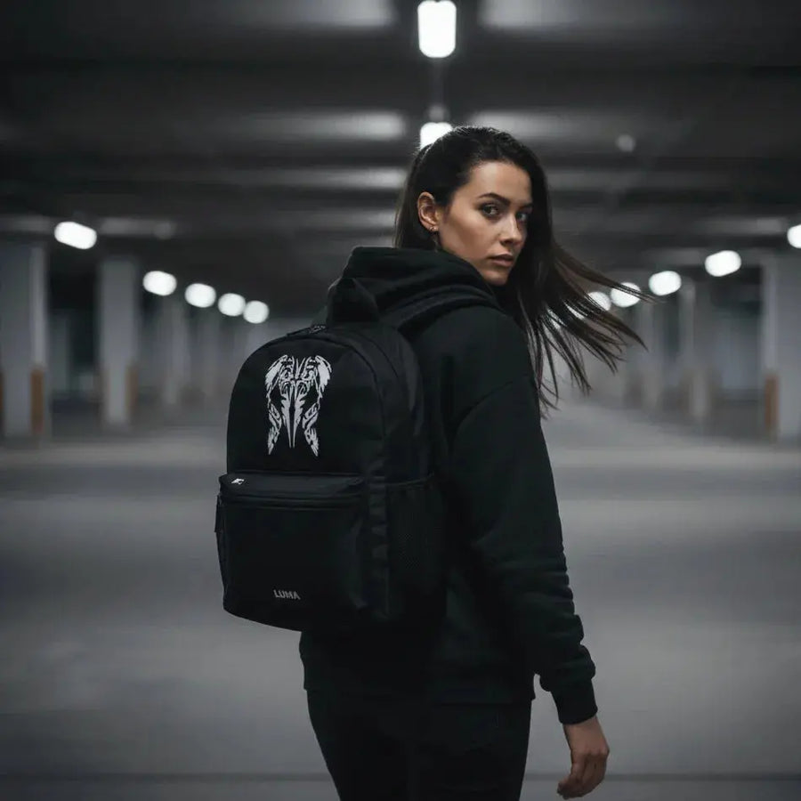 Woman glancing back while wearing the LUMA Tribal Ram backpack in an urban parking garage