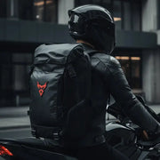 Rider carrying the LUMA MotoPack Pro backpack on a city street, alternate angle