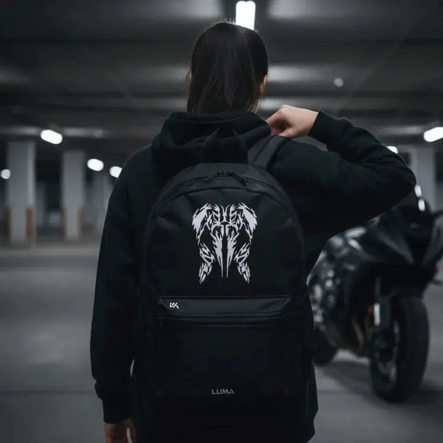 Woman adjusting the LUMA Tribal Ram backpack strap, motorcycle visible in background