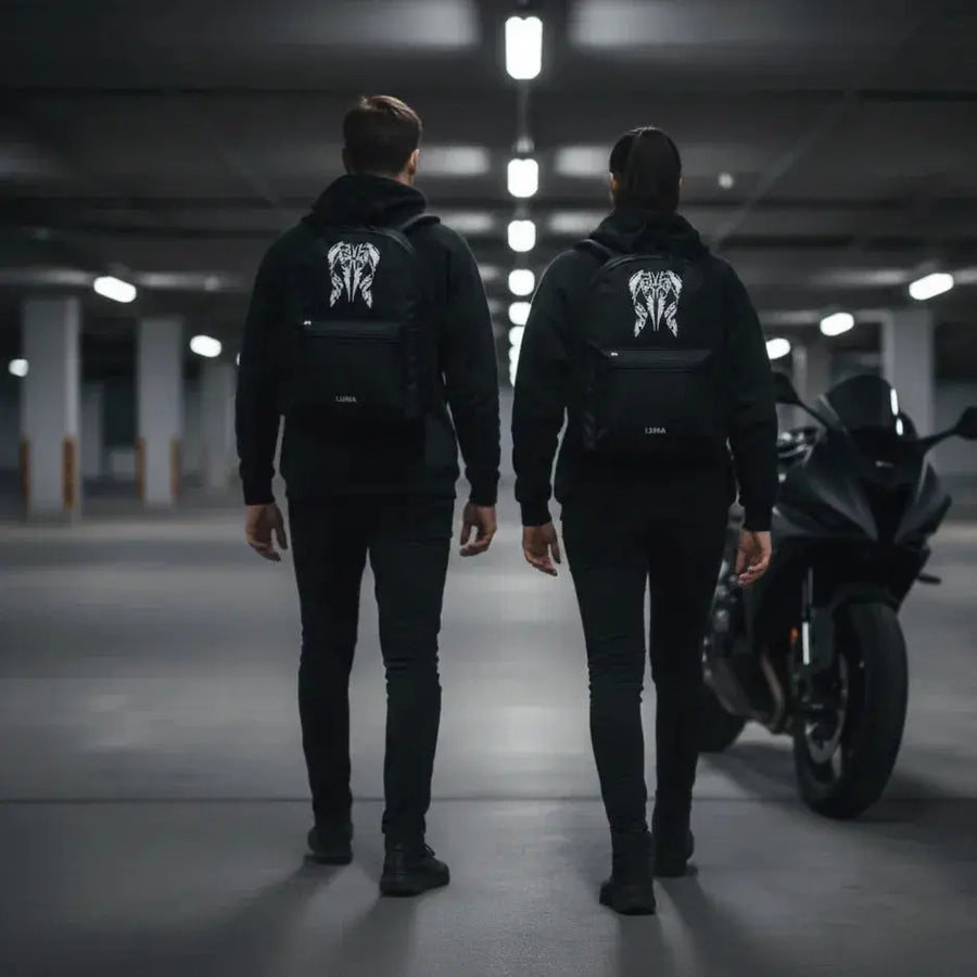 Two people wearing LUMA Tribal Ram backpacks walking toward a motorcycle in a parking garage