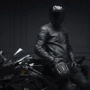 Motorcyclist in leather jacket and helmet with the LUMA Leg Bag strapped to his thigh, seated on a sportbike