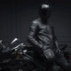 Motorcyclist in leather jacket and helmet with the LUMA Leg Bag strapped to his thigh, seated on a sportbike