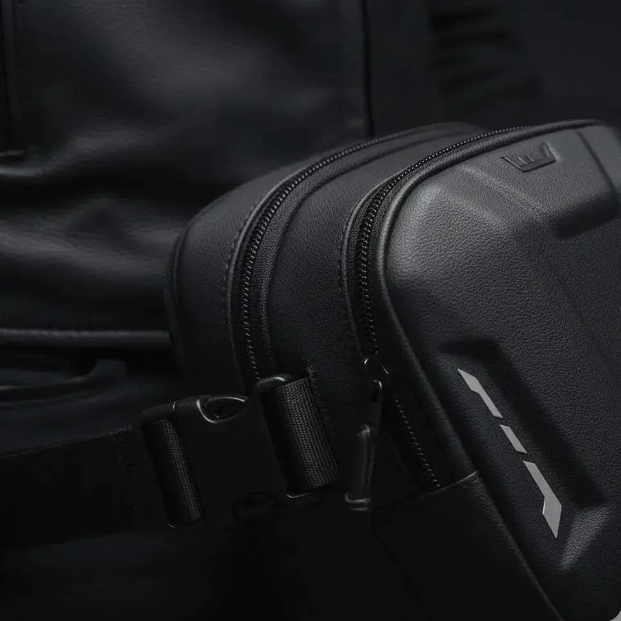 Close-up of the LUMA Leg Bag's zippers, buckle strap, and logo detail