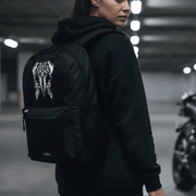 Woman wearing the LUMA Tribal Ram backpack in a parking garage, tribal skull graphic visible