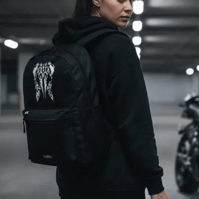 Woman wearing the LUMA Tribal Ram backpack in a parking garage, tribal skull graphic visible