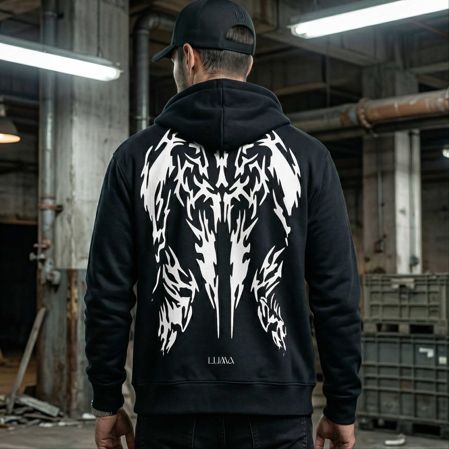 Man wearing the LUMA Rider hoodie and cap, back view, industrial warehouse setting