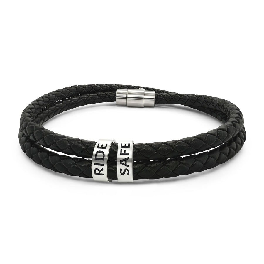 Personalized black braided leather bracelet for men with two engraved stainless steel beads reading RIDE and SAFE (product mockup)