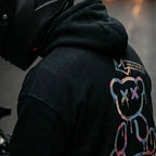 Motorcycle rider wearing the LUMA Graffiti Bear hoodie — premium black streetwear for US riders.