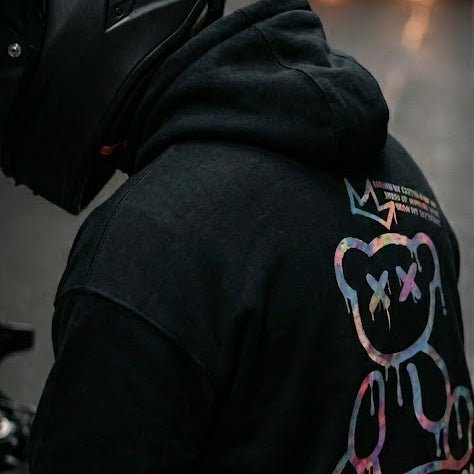 Motorcycle rider wearing the LUMA Graffiti Bear hoodie — premium black streetwear for US riders.