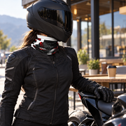 Woman rider in a black helmet and jacket wearing a motorcycle neck gaiter at a cafe