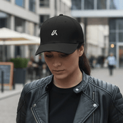 Woman wearing the LUMA Rider snapback cap and leather jacket on a city sidewalk